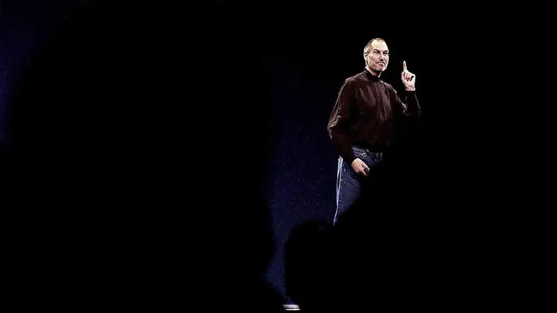 Steve Jobs hält eine Rede vor einem schwarzen Hintergrund