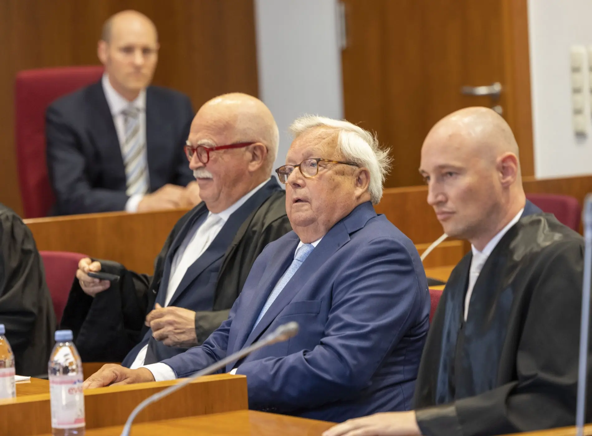 Das Bild zeigt Bankier Christian Olearius zwischen seinen Anwälten im Gerichtssaal.