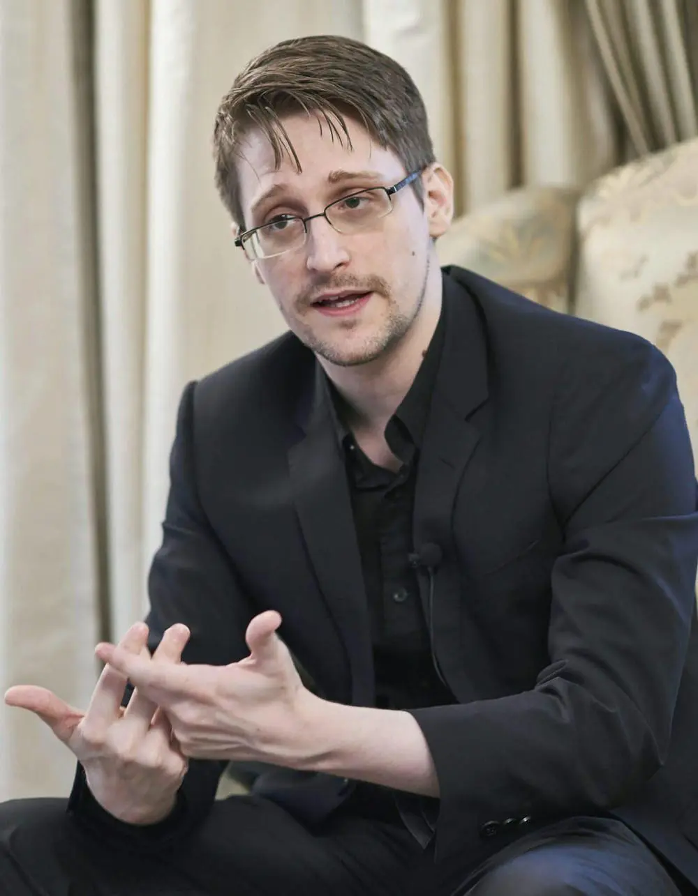 Edward Snowden im schwarzen Anzug gestikuliert