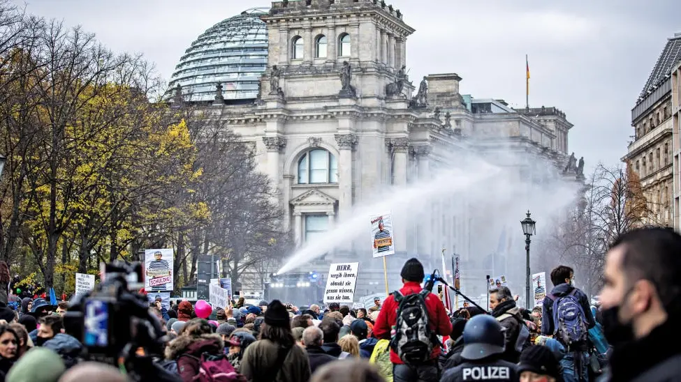 Demonstranten vor dem Reichstagsgebäude, die Polizei setzt Wasserwerfer ein. 