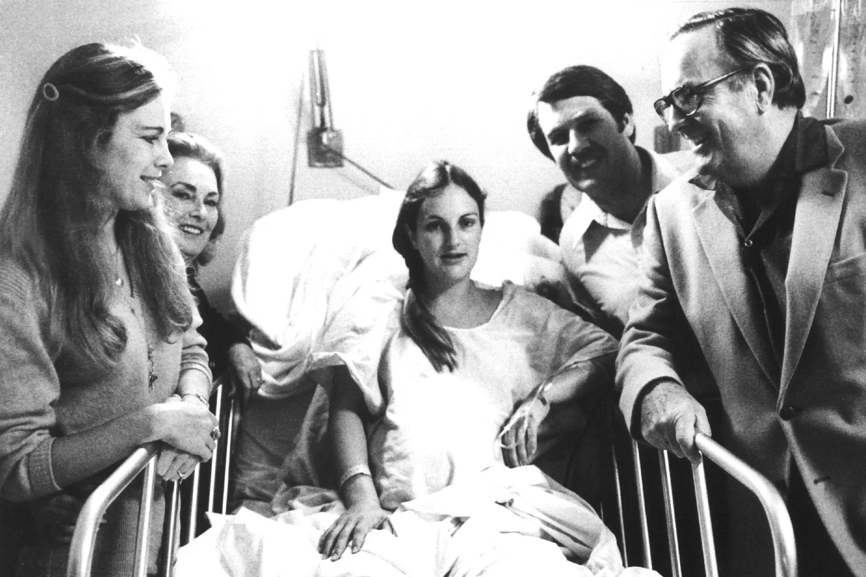 Schwarz-Weiß-Foto von Frau mit Familie nach der Geburt im Krankenhaus