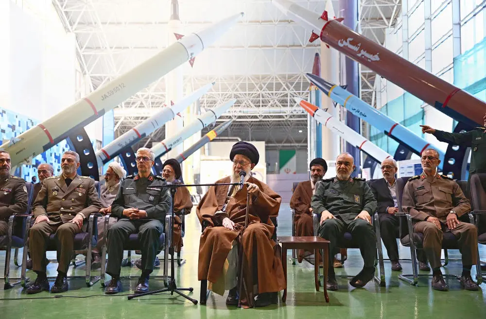 Führer und Mitglieder der Revolutionsgarde sitzen nebeneinander in einer Halle