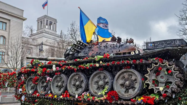 Ein mit Blumen geschmückter Panzer mit ukrainischer Flagge
