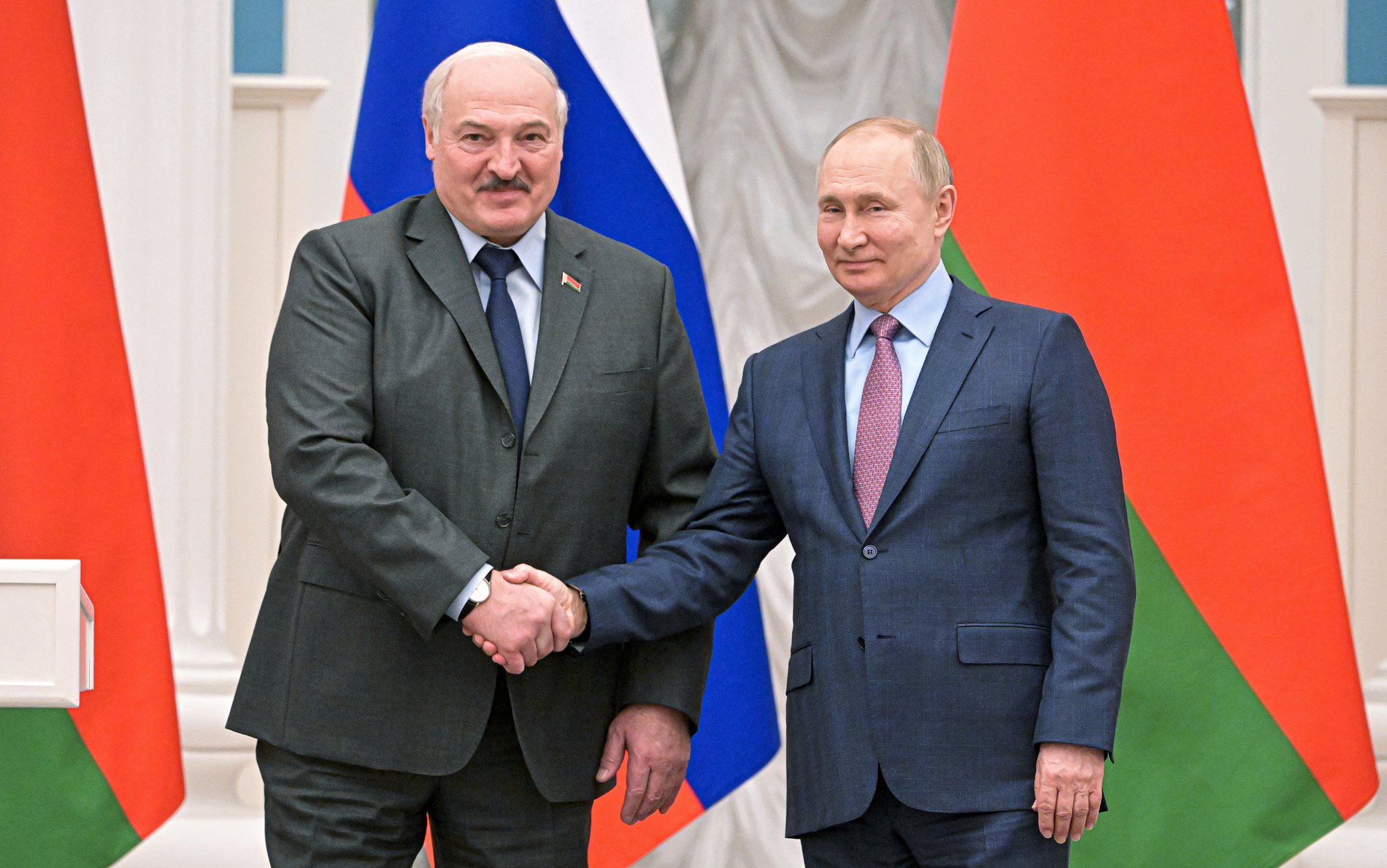 Alexander Lukaschenko und Wladimir Putin geben sich die Hand.