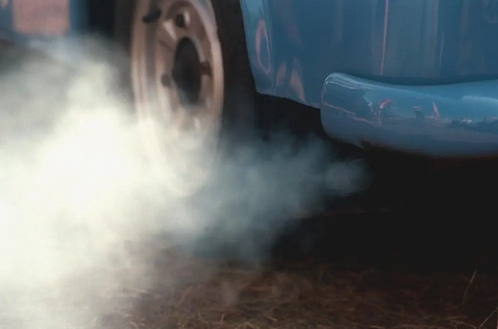 Abgaswolke Eine dicke graue Abgaswolke aus einem Auto ohne geregelten Katalysator