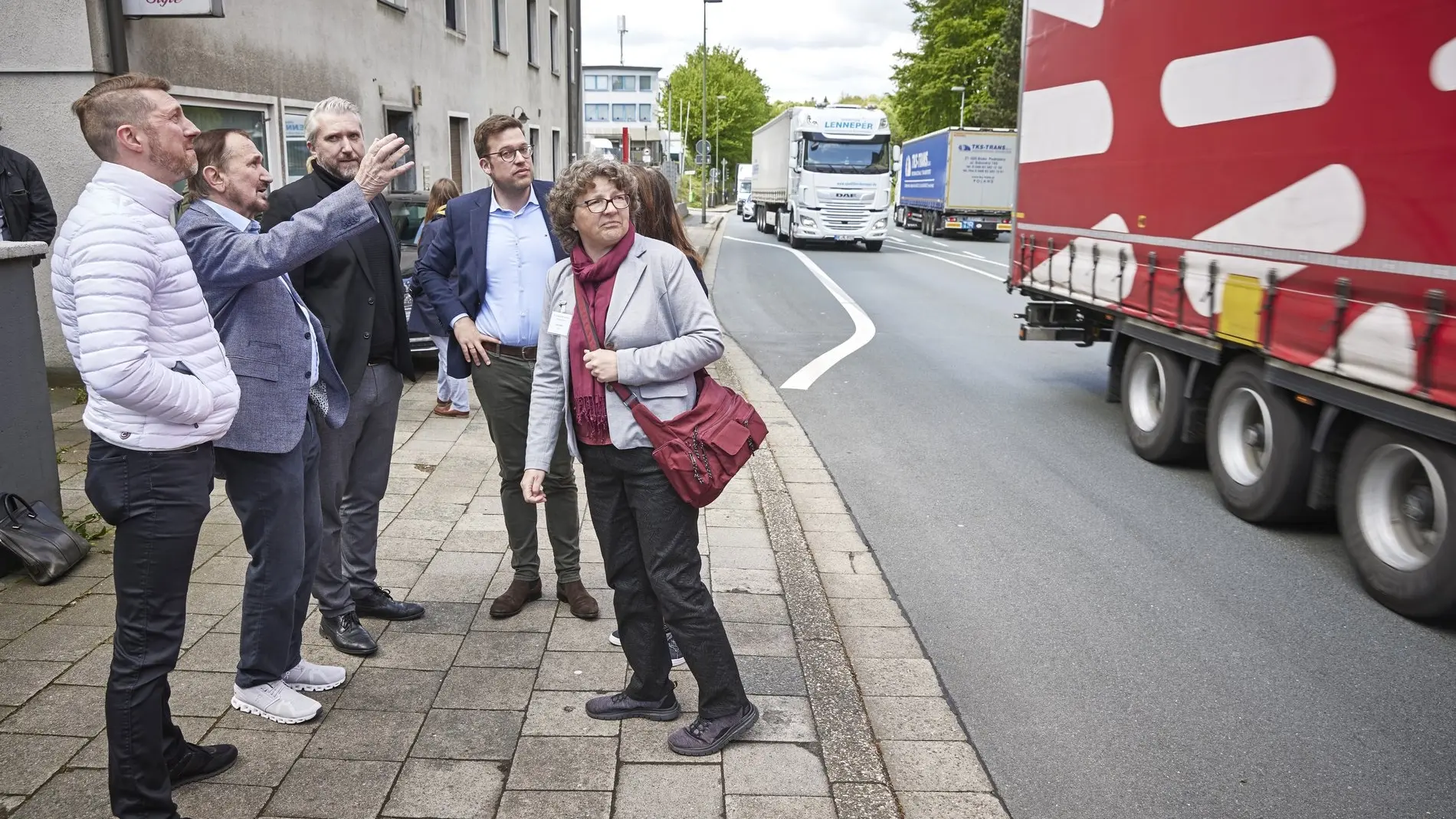 Sechs Personen schauen sich die Verkehrslage an einer Straße in Lüdenscheid an.