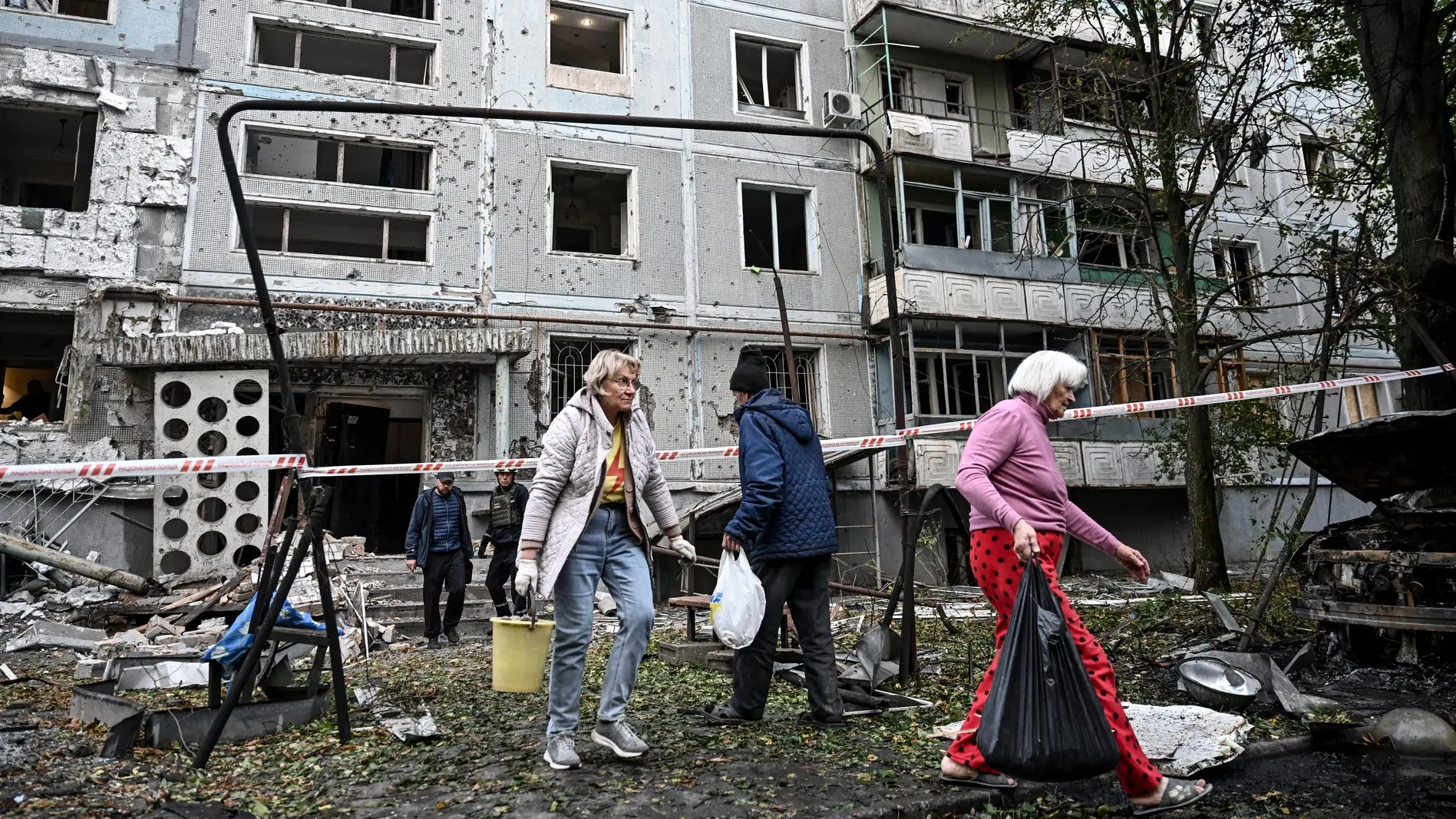 Ukrainer vor einem zerstörten Gebäude