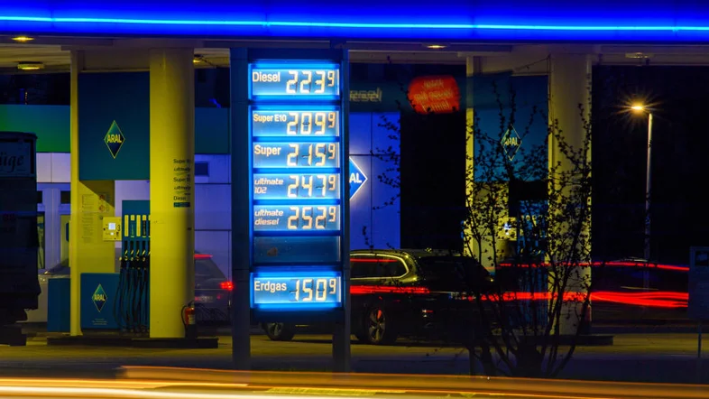 Autos fahren an einer Preistafel einer Tankstelle vorbei