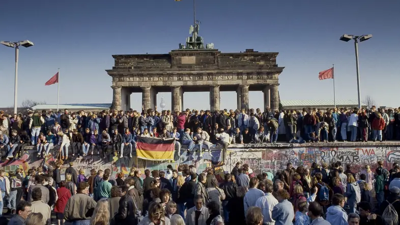 Menschen aus Ost- und West-Berlin sind auf die Mauer am Brandenburger Tor geklettert.