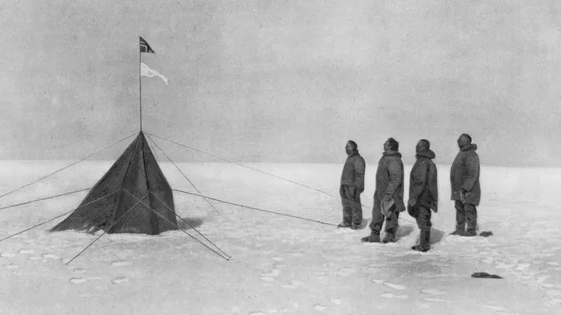 Roald Amundsen und seine Mannschaft blicken am Südpol auf die norwegische Flagge