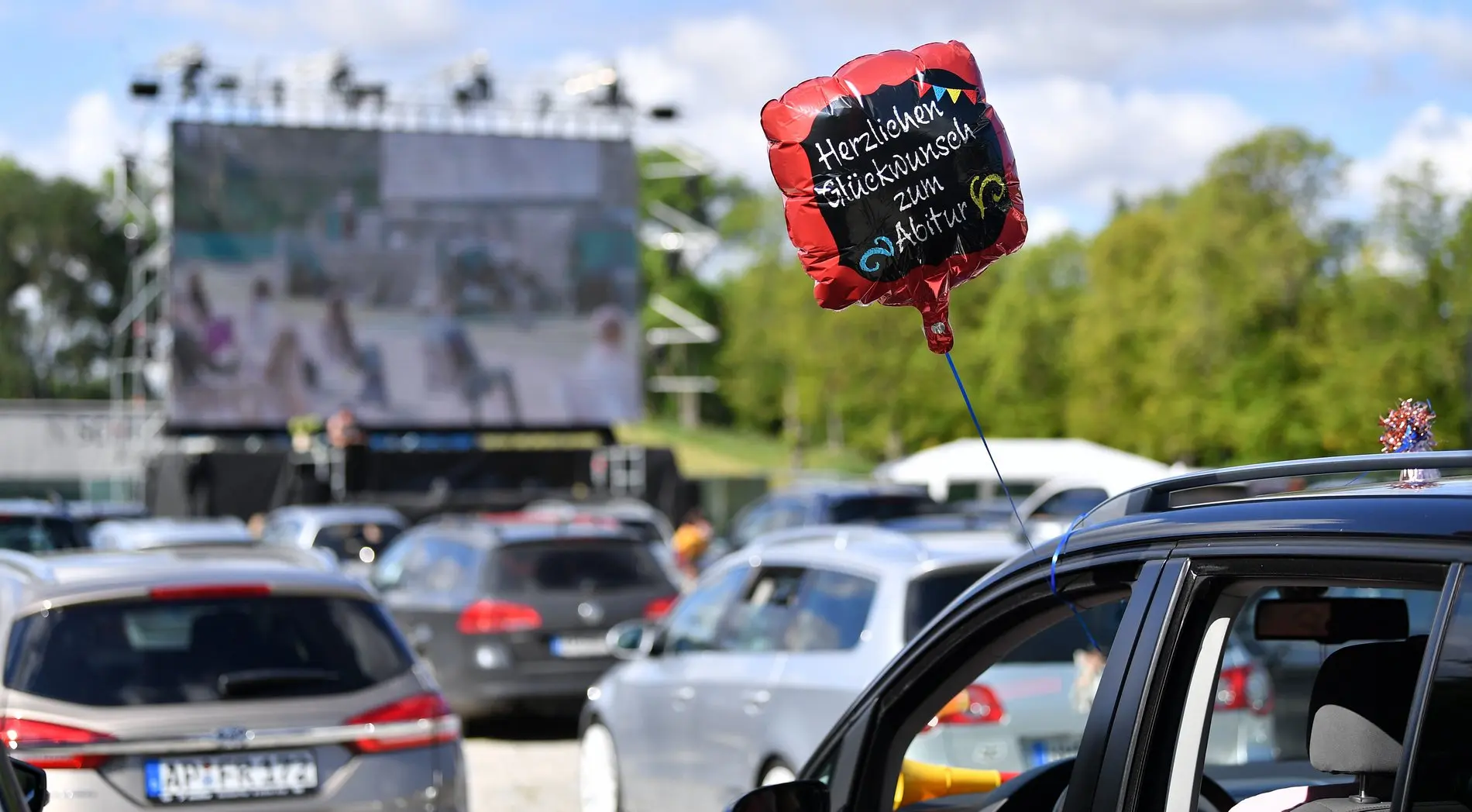 Abiturverleihung zu Covid-Zeiten Glückwunsch-zum-Abitur-Luftballon an einem Auto