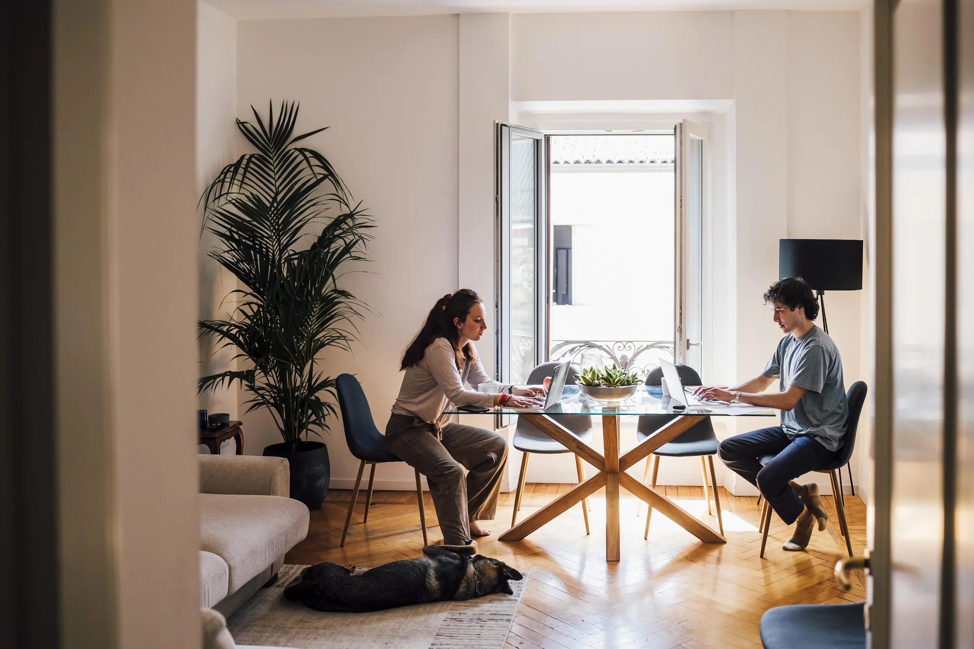 Ein Paar sitzt am Tisch mit Laptops