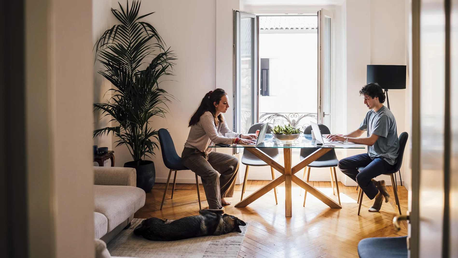 Ein Paar sitzt am Tisch mit Laptops