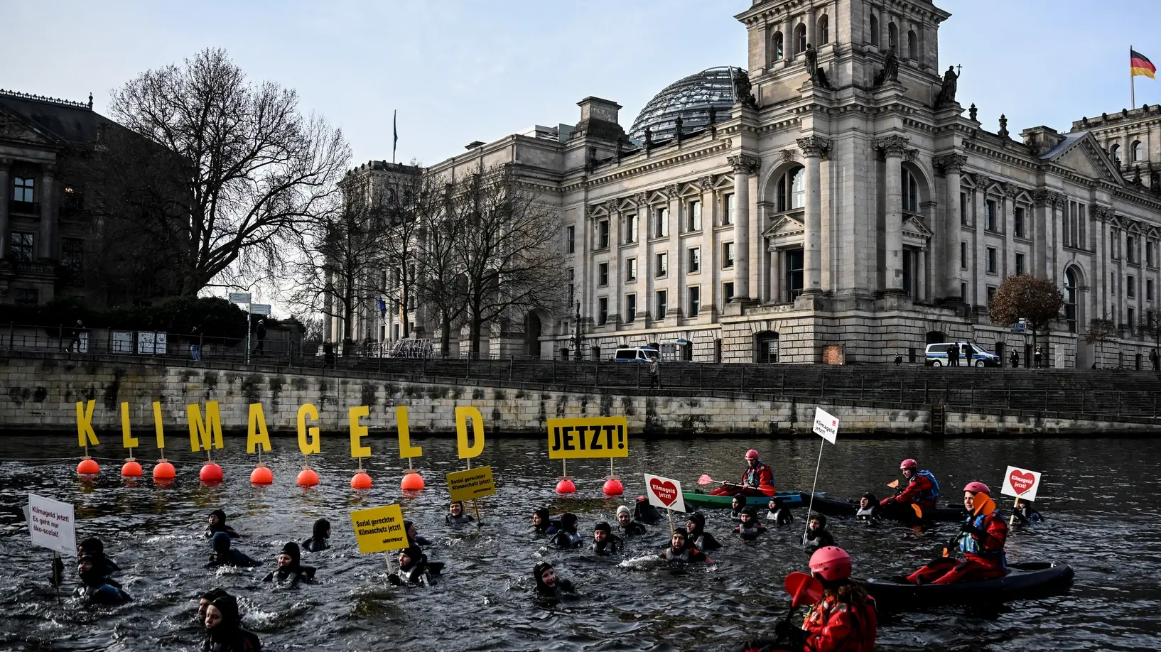 Aktivisten schwimmen und paddeln in der Spree für eine schnelle Einführung des Klimagelds.