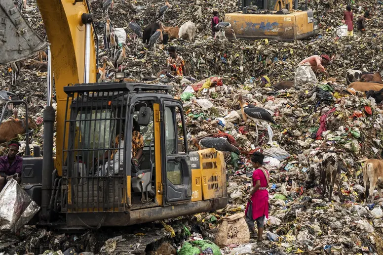 Müllsammler auf der Suche nach wiederverwertbarem Material auf einer Mülldeponie in Assam, Indien