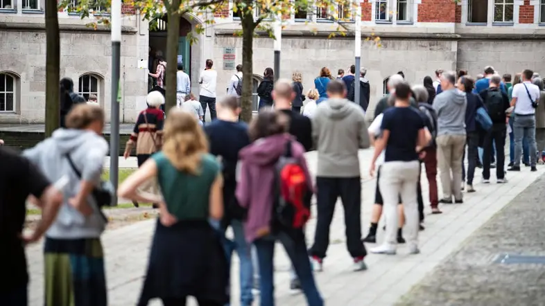 Wähler stehen in einer Schlange vor einem Wahllokal