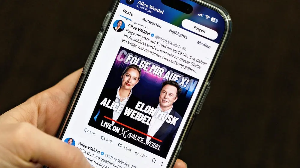 Elon Musk im Gespräch mit Alice Weidel Auf einem Handybildschirm ist der X-Talk zwischen Weidel und Musk zu sehen.