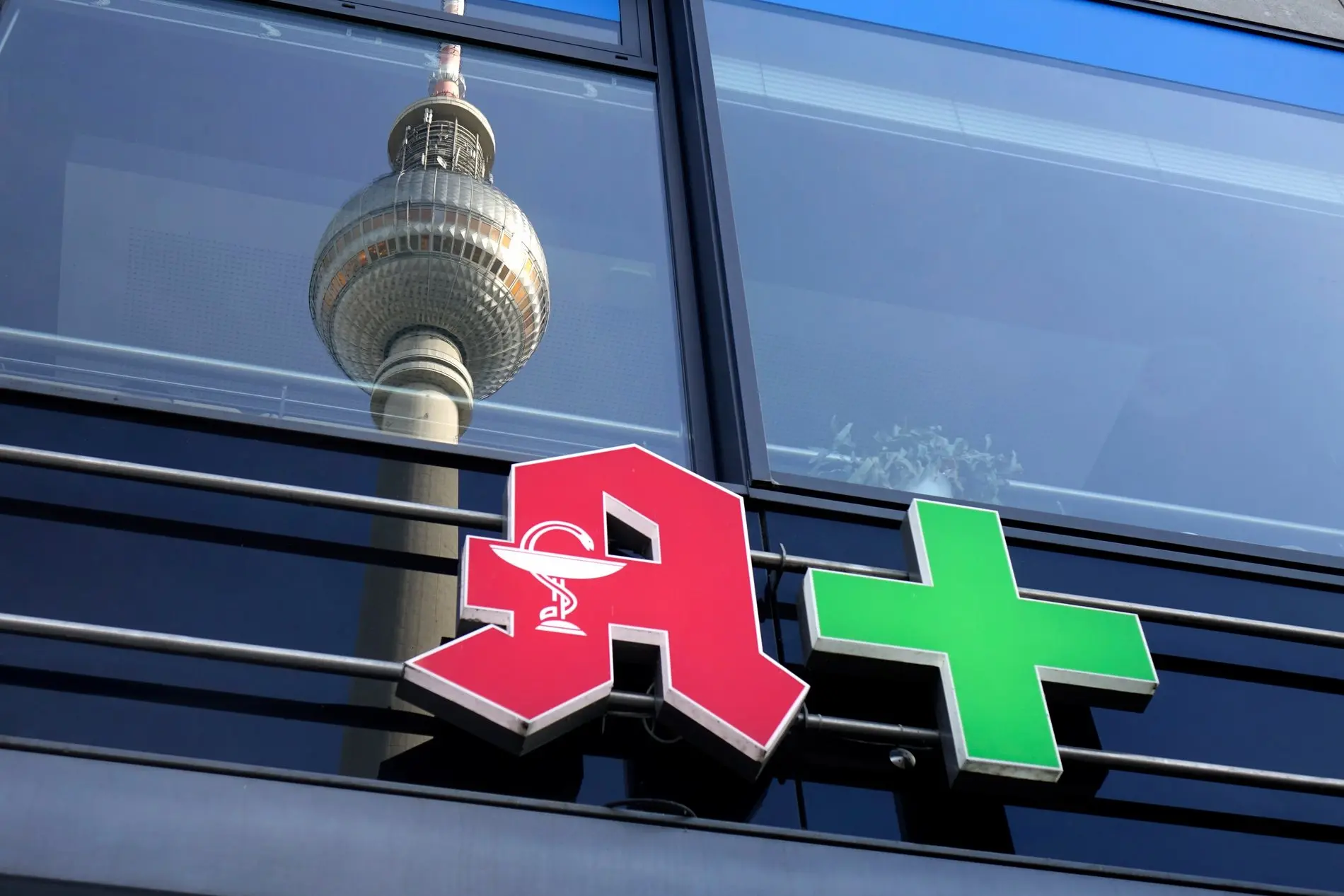 Über dem Logo einer Apotheke spiegelt sich der Berliner Fernsehturm