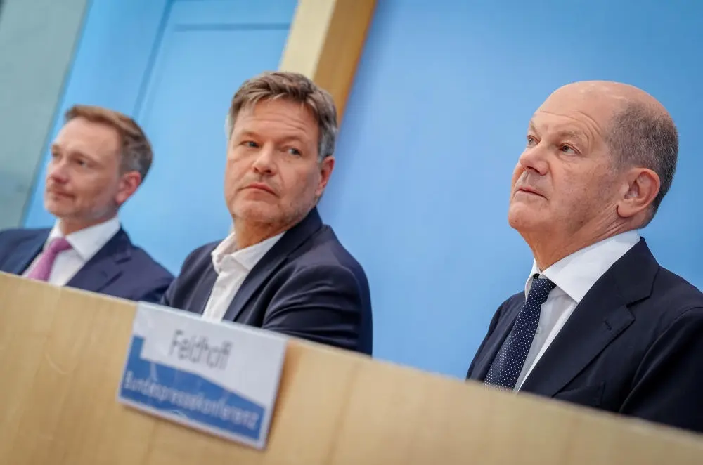 Haushalt 2025 Christian Lindner, Robert Habeck und Olaf Scholz vor einer blauen Wand