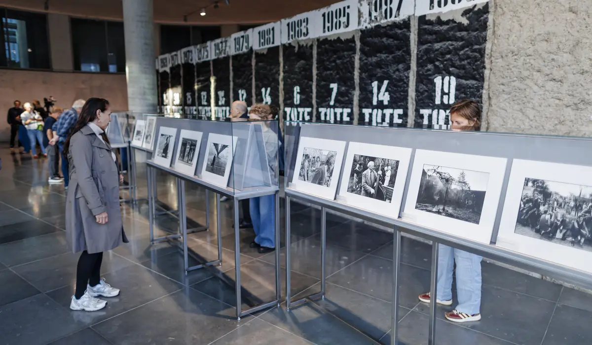 Besucher besuchen die Veranstaltung am Mauer-Mahnmal