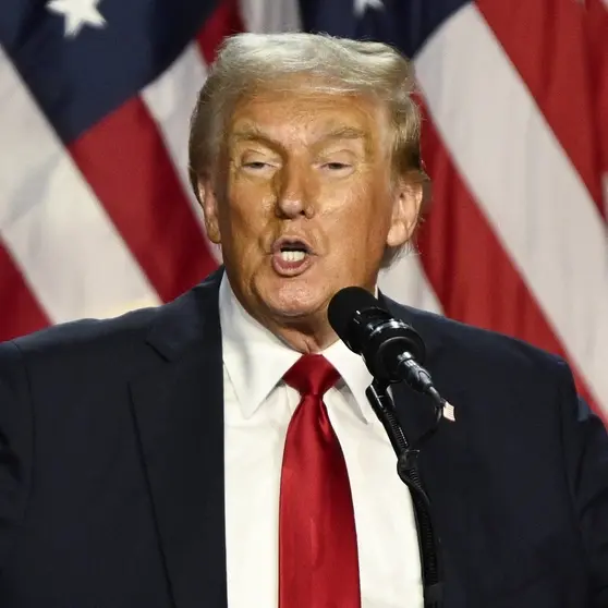 Donald Trump am Rednerpult, hinter ihm seine Frau Melania vor der US-Flagge