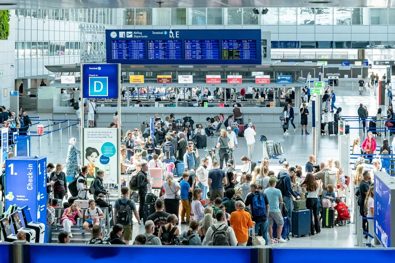 Hunderte Menschen warten in Schlangen an den Schaltern eines Flughafens