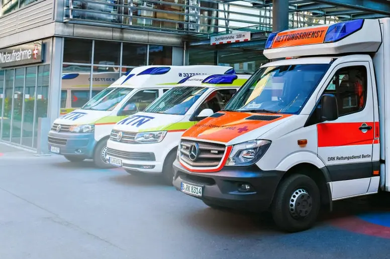 Drei nebeneinander geparkte Krankenwagen.