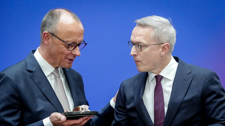 Friedrich Merz und Karsten Wildberger essen Geburtstag-Kuchen