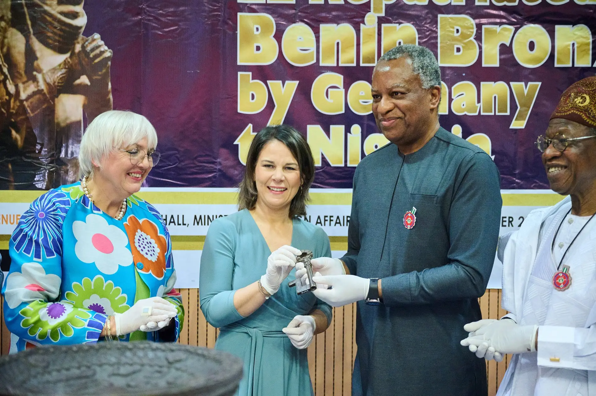 Claudia Roth, Annalena Baerbock, Geoffrey Onyeama und Alhaji Lai Mohammed stehen bei der Übergabe der Benin-Bronzen im Dezember 2022 im Außenministerium in Berlin zusammen.