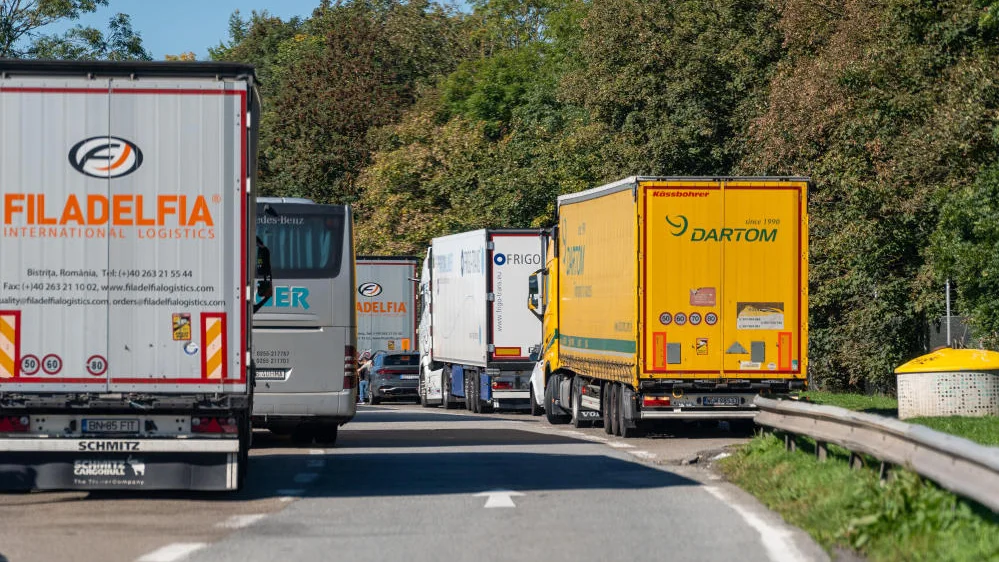 Zahlreiche Lkw und ein Reisebus stehen dicht an dicht auf einem Rastplatz