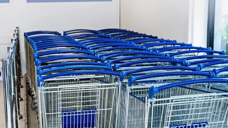 Blaue Einkaufswagen in einer Box für Einkaufswagen vor einem Supermarkt