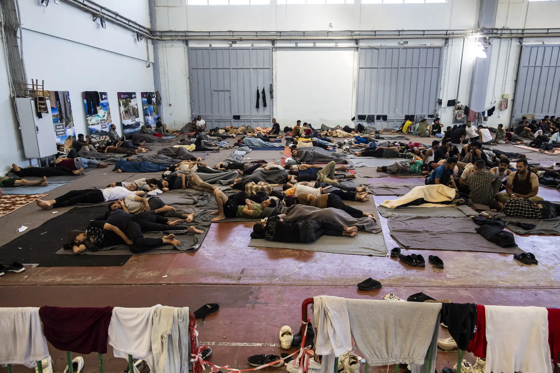 Blick in eine Flüchtlingsunterkunft in der Menschen auf dem Boden schlafen.