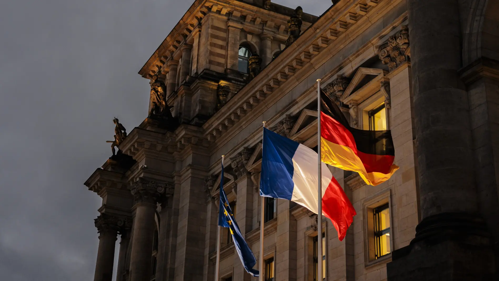 Die Flagge von Frankreich weht zwischen der deutschen und europäischen Flagge