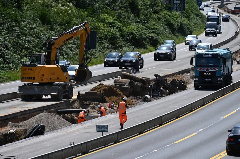 Bauarbeiter und Baumaschinen bei der Arbeit auf der Autobahnbaustelle der A59 