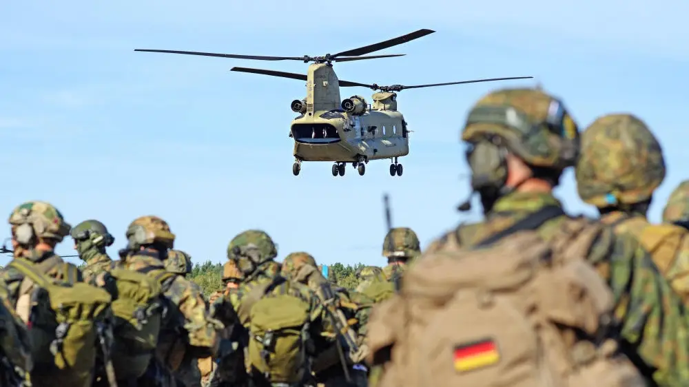 Ein Hubschrauber fliegt über Bundeswehrsoldaten hinweg.