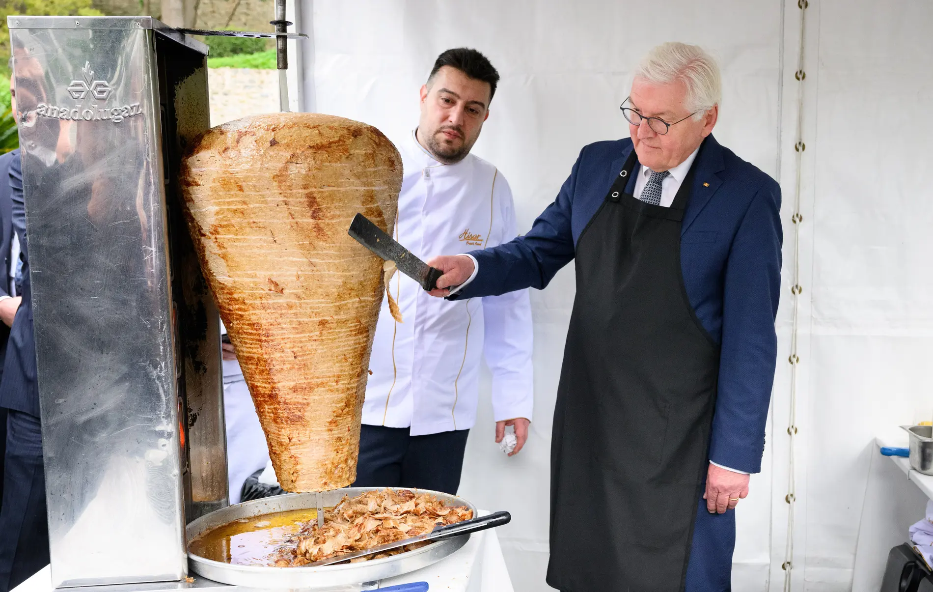 Frank-Walter Steinmeier und Arif Keles schneiden einen Dönerspieß