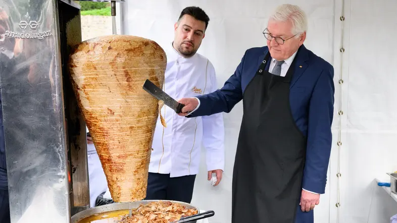 Frank-Walter Steinmeier und Arif Keles schneiden einen Dönerspieß