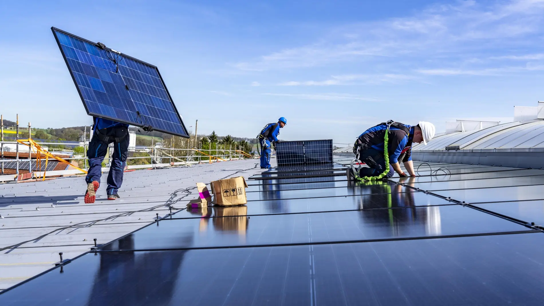 Handwerker montieren Solarmodule auf einem Dach