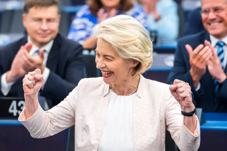 Ursula von der Leyen lächelt und hebt beide Fäuste als Zeichen der Freude