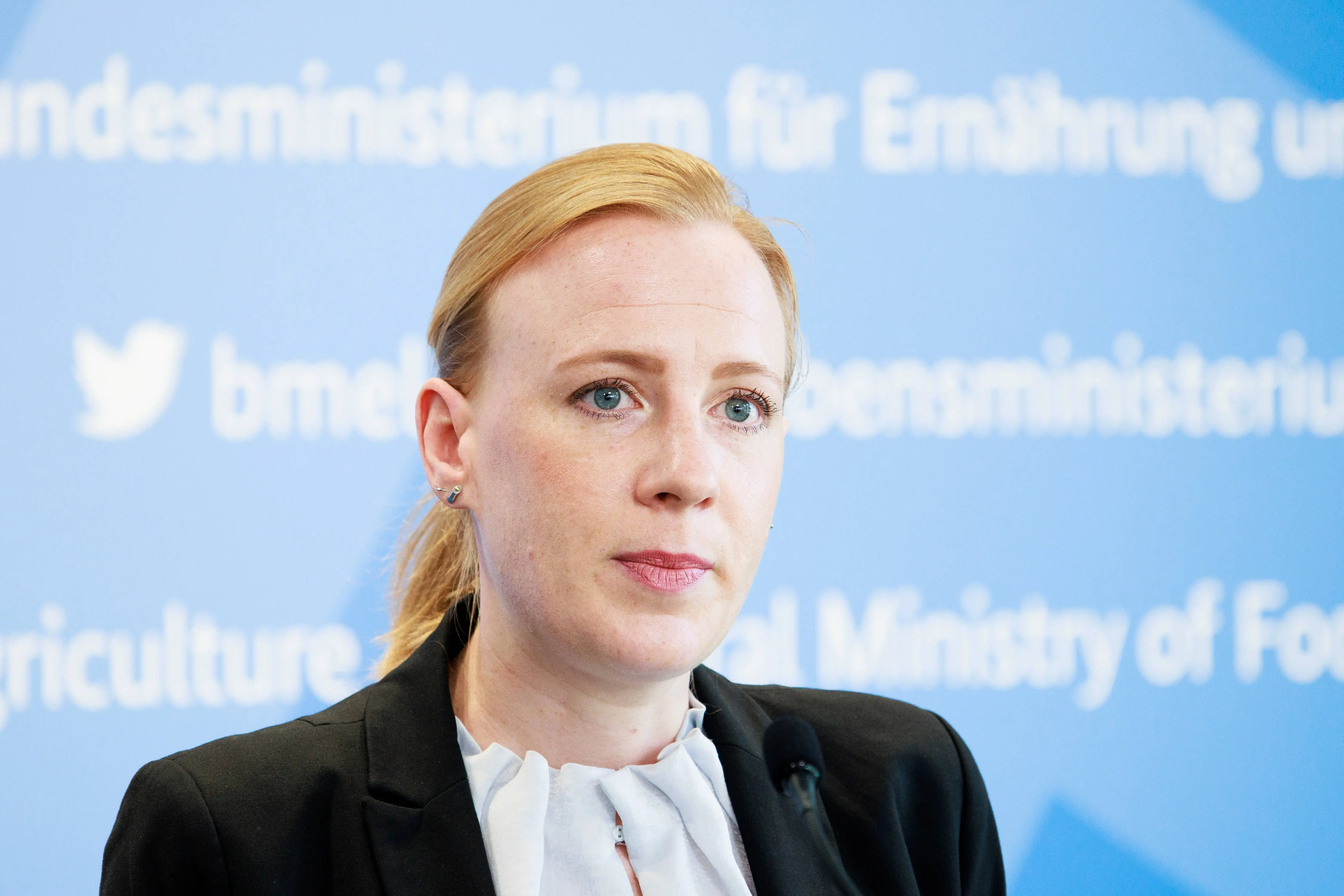 Ariane Kari vor einer blauen Pressewand