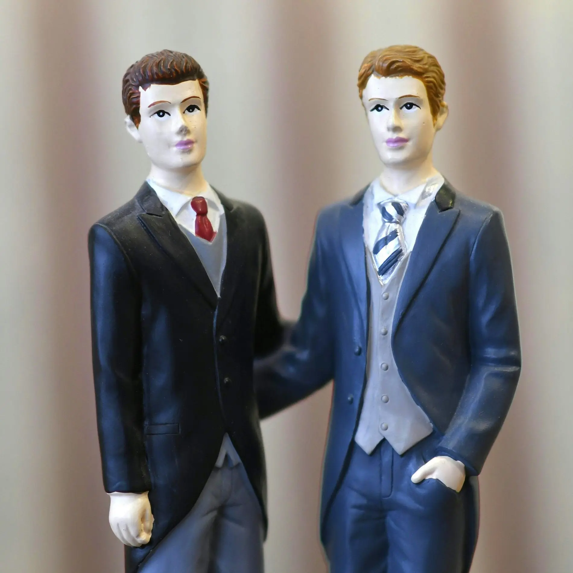 Zwei männliche Figuren im Anzug mit Krawatte