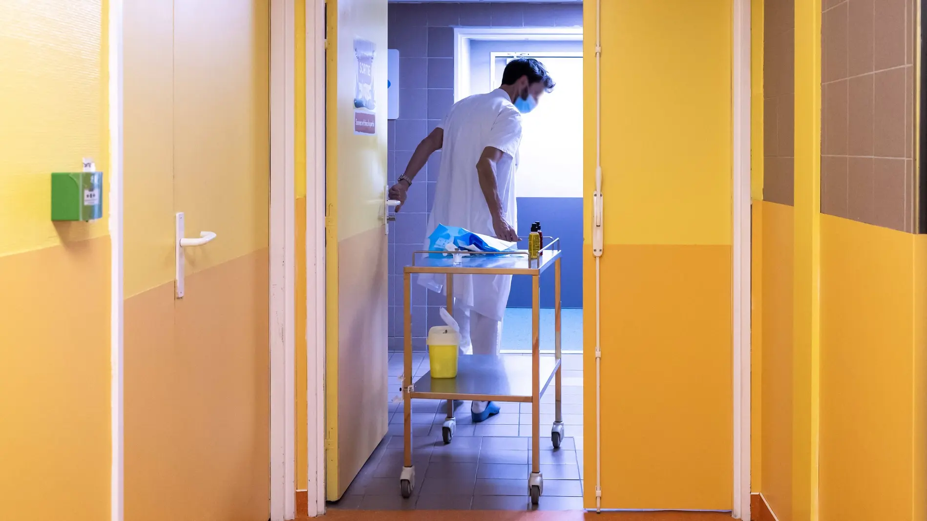 Ein Pfleger zieht einen Waagen hinter sich her.