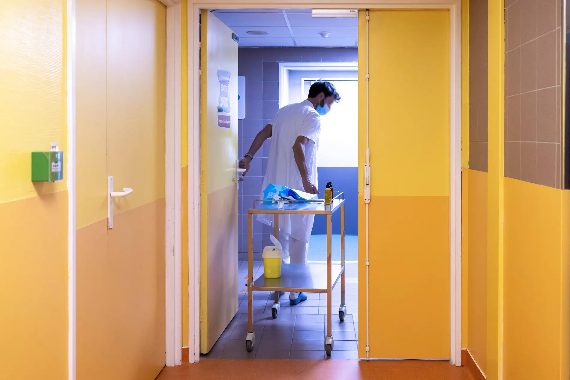 Ein Pfleger zieht einen Waagen hinter sich her.