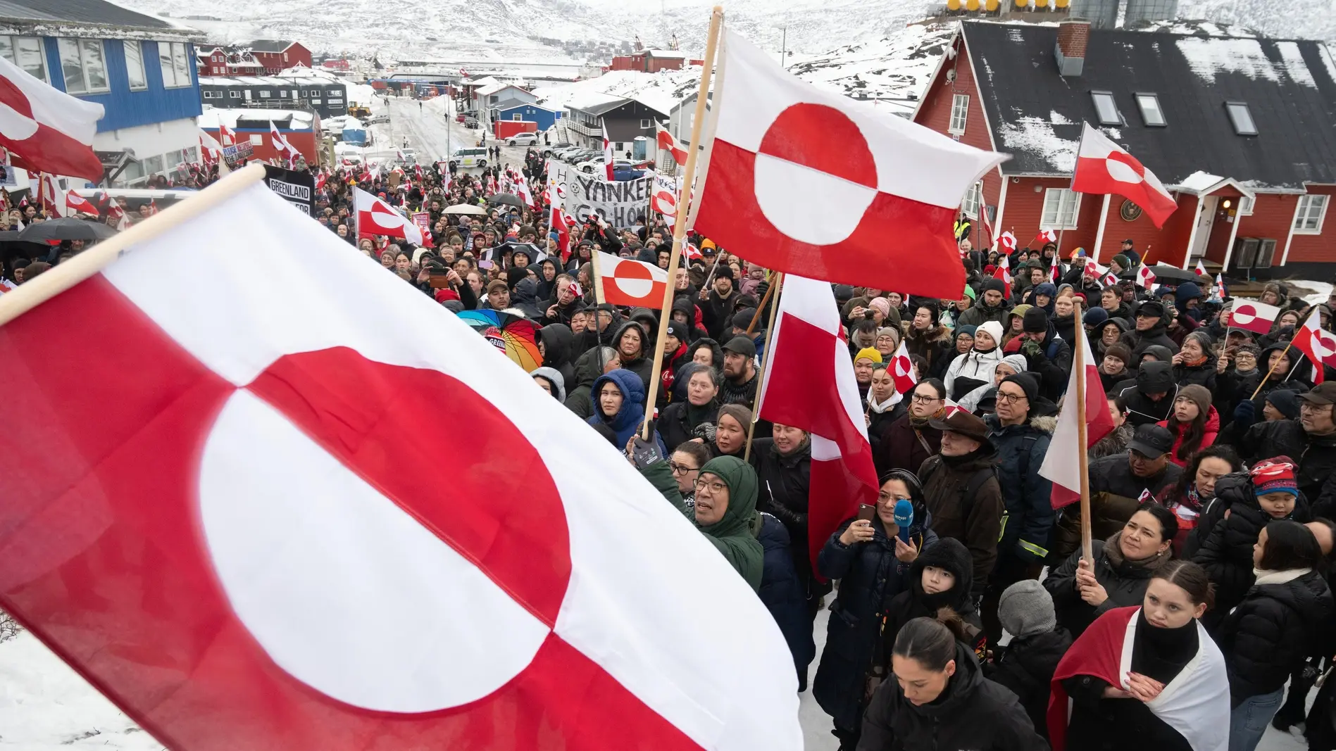 Menschen schwenken Fahnen bei Protesten in Grönland
