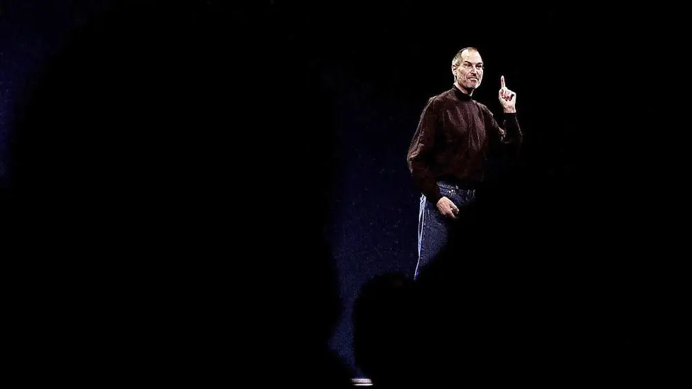 Steve Jobs hält eine Rede vor einem schwarzen Hintergrund