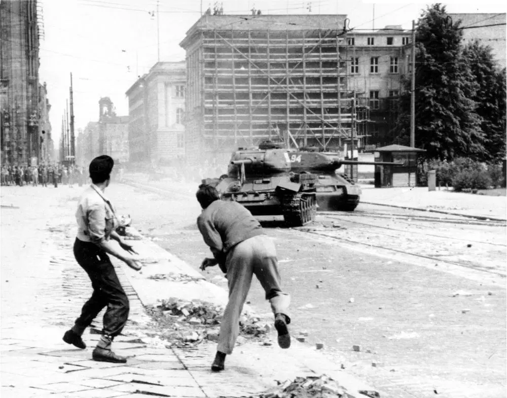 DDR-Volksaufstand 1953 Zwei Demonstranten werfen Steine auf einen sowjetischen Panzer in Ostberlin.