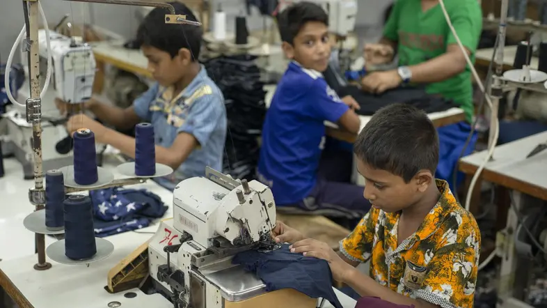 Kinder arbeiten an Nähmaschinen