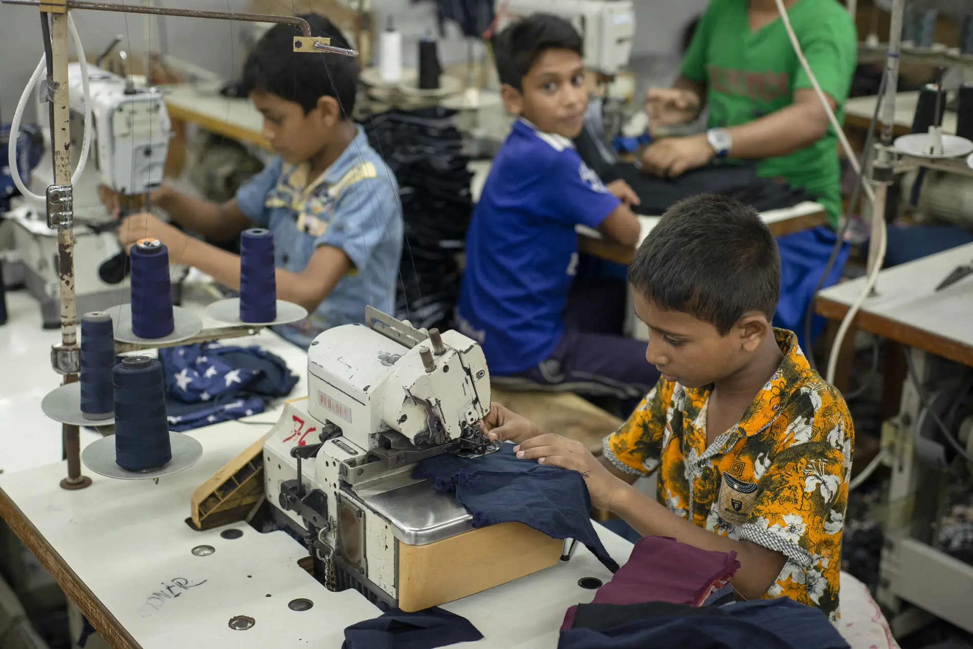 Kinder arbeiten an Nähmaschinen