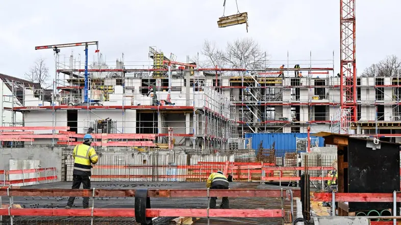 Arbeiter errichten auf einer Baustelle ein Haus.