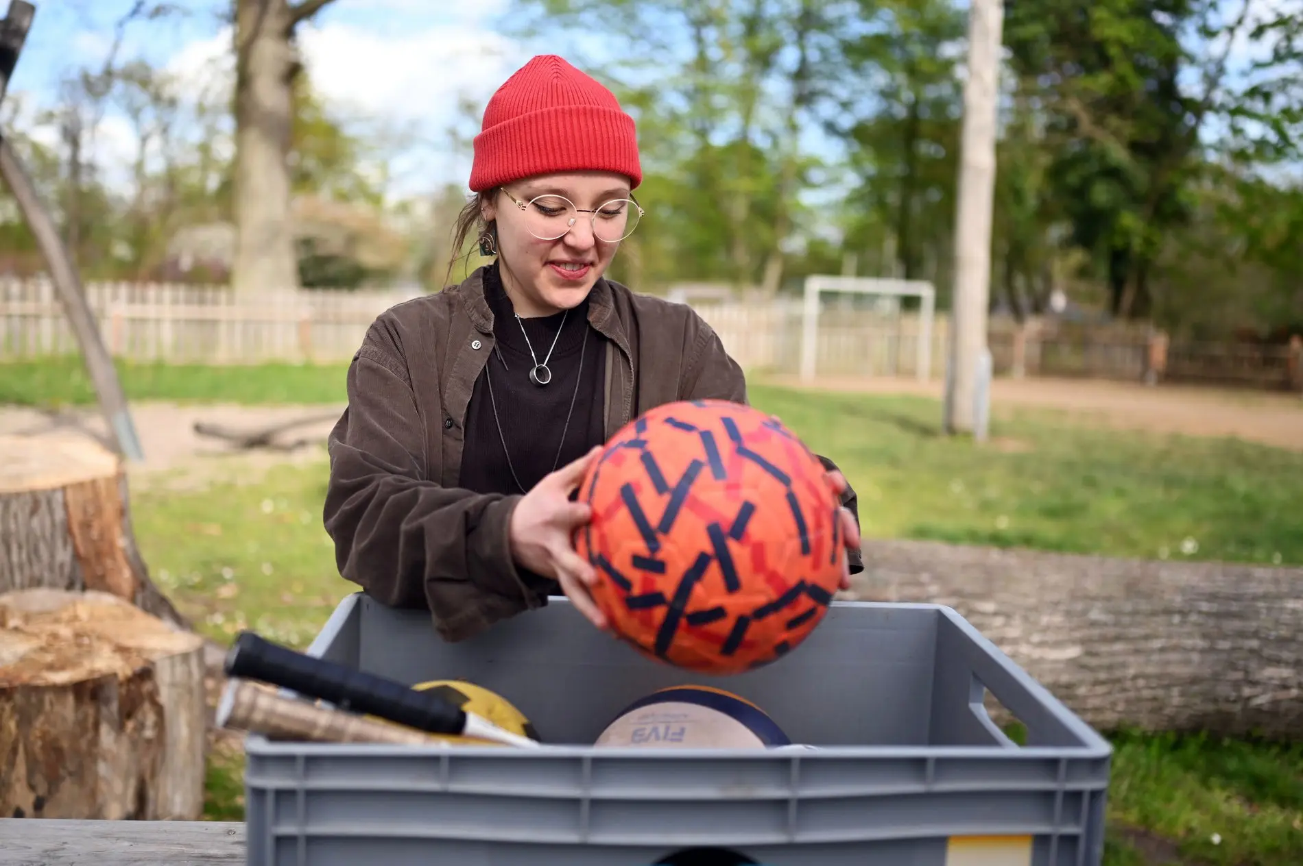 Eine junge Frau sortiert Spielzeug in einem Kletterpark